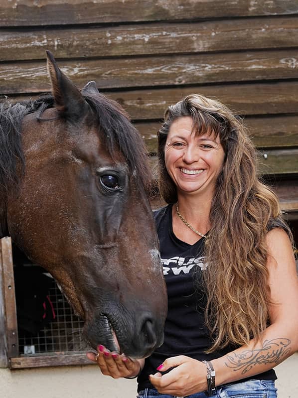 Femme souriante avec un cheval.